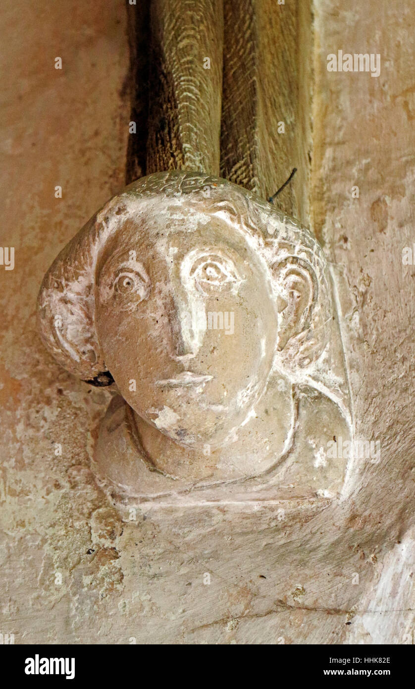 Une tête de pierre sculptée dans le support de l'Afrique du porche de l'église paroissiale de North Elmham, Norfolk, Angleterre, Royaume-Uni. Banque D'Images