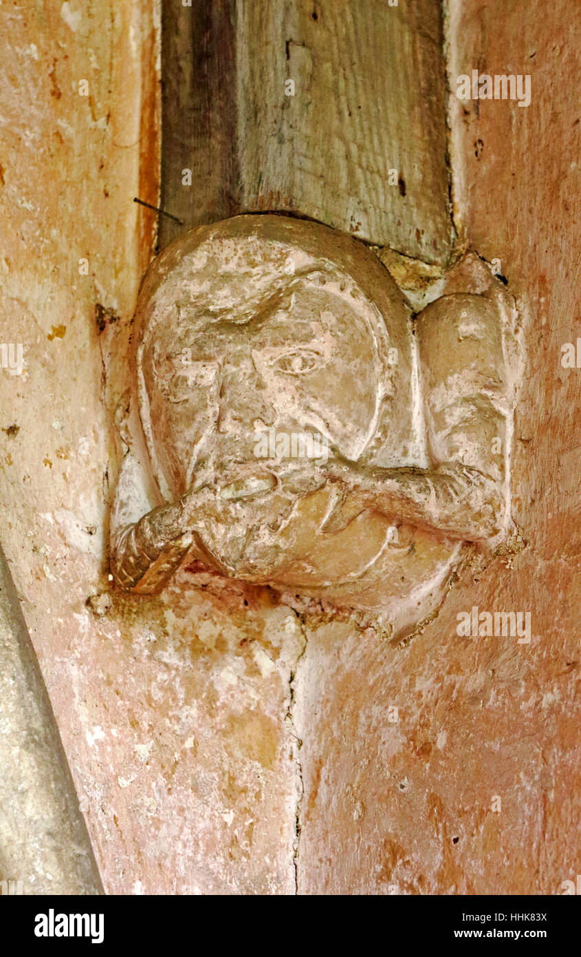 Une tête de pierre sculptée dans le support de l'Afrique du porche de l'église paroissiale de North Elmham, Norfolk, Angleterre, Royaume-Uni. Banque D'Images