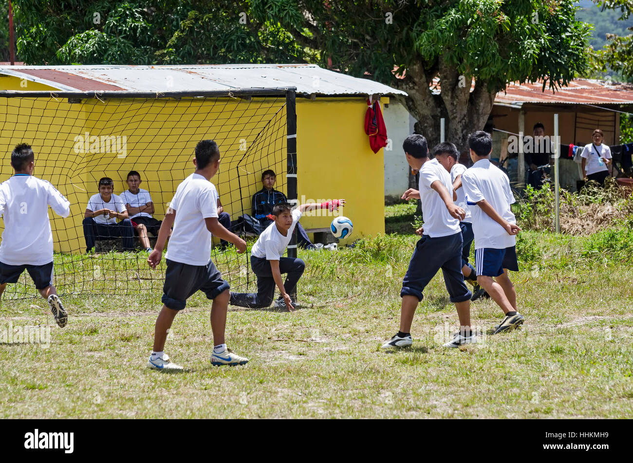 Certains élèves de l'école de Kamarata, situé dans le parc national Canaima, Venezuela jouer une partie de soccer, dans leur domaine de sports ayant background Banque D'Images
