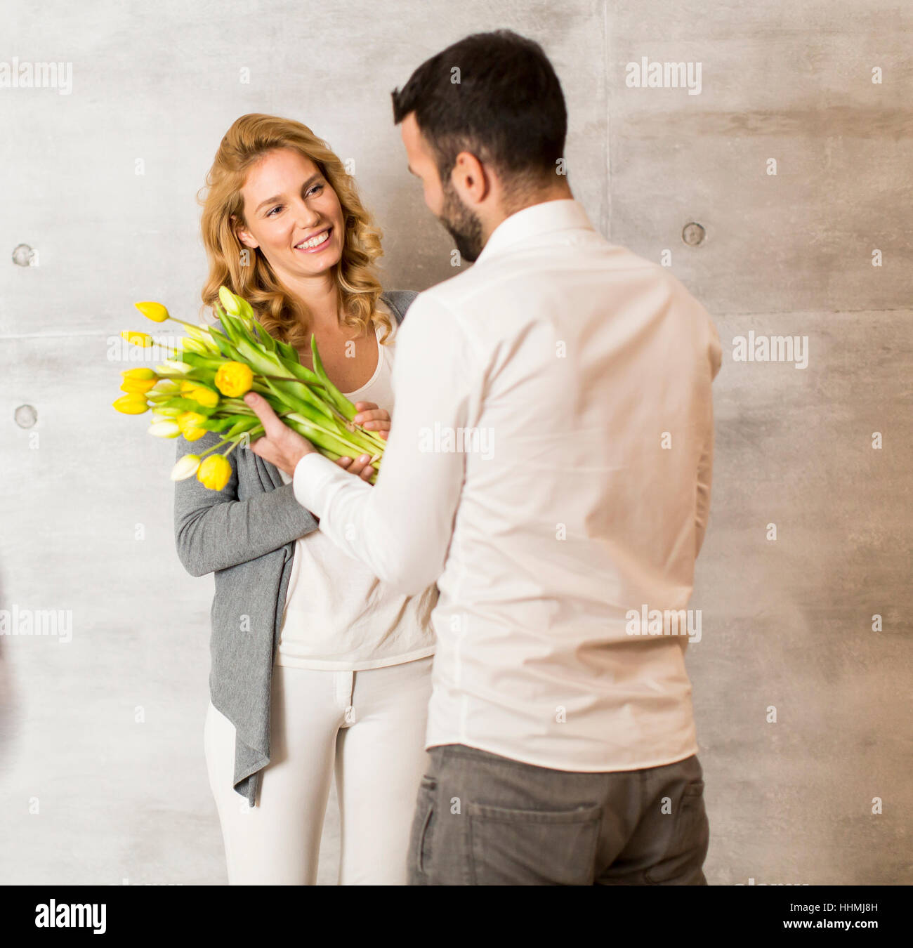 Jeune homme donnant à la fille un bouquet de tulipes Banque D'Images