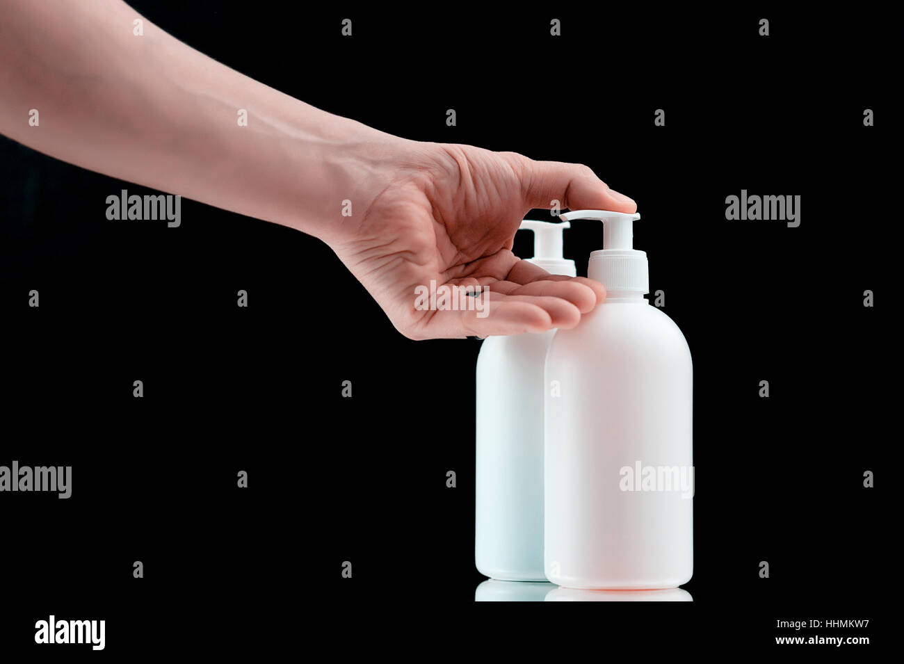 Distributeur en plastique avec du savon liquide sur un fond noir. Banque D'Images