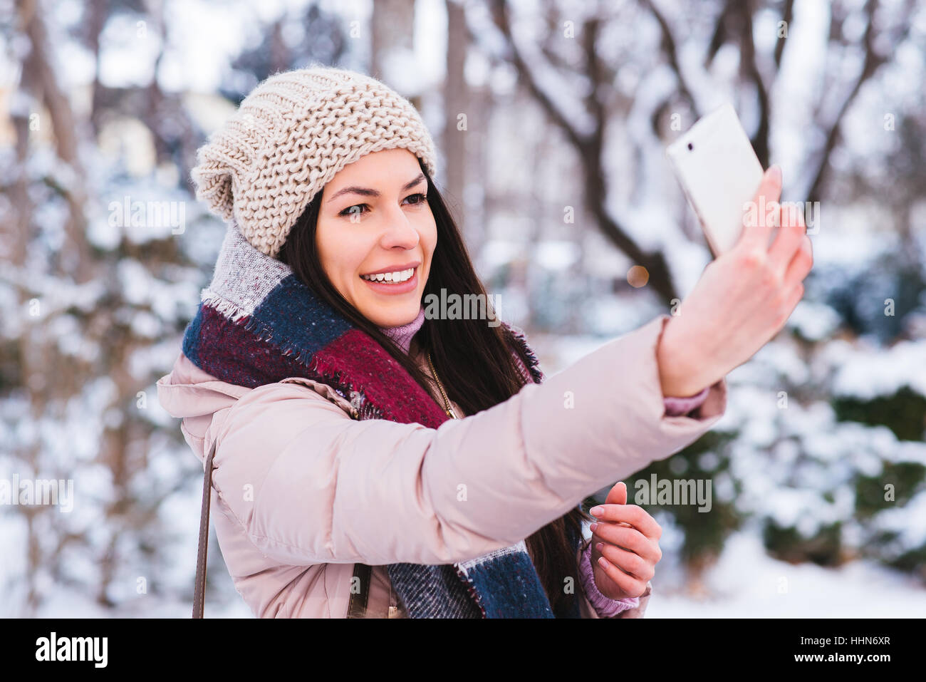 Young woman taking self portrait with smart phone piscine Banque D'Images