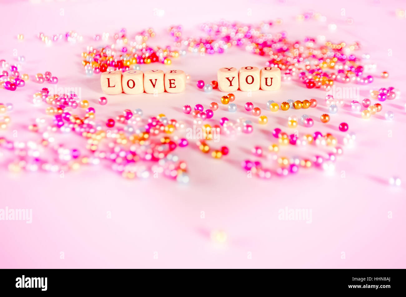 Love you text avec perles multicolores avec ambiant rosâtre. Banque D'Images