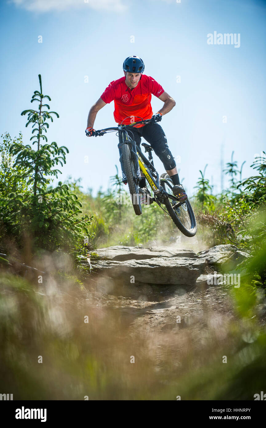 Un vélo de montagne monte un sentier rocheux au Bikepark de galles près de la ville de Merthyr Tydfil au Pays de Galles. Banque D'Images