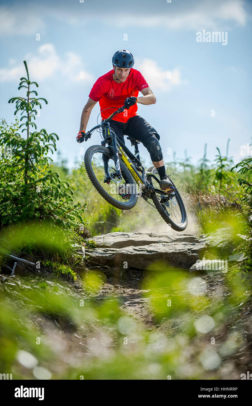 Un vélo de montagne monte un sentier rocheux au Bikepark de galles près de la ville de Merthyr Tydfil au Pays de Galles. Banque D'Images