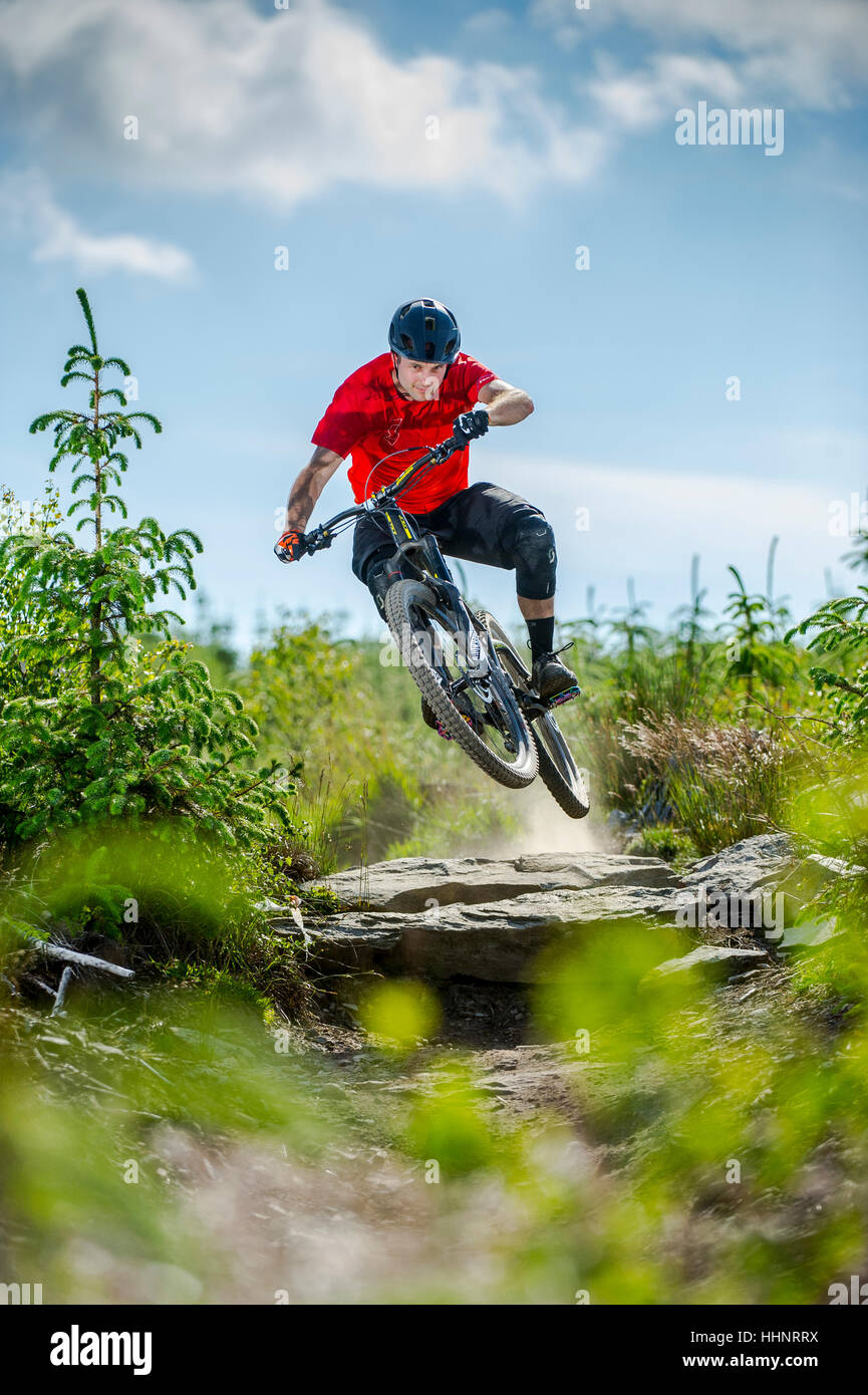 Un vélo de montagne monte un sentier rocheux au Bikepark de galles près de la ville de Merthyr Tydfil au Pays de Galles. Banque D'Images