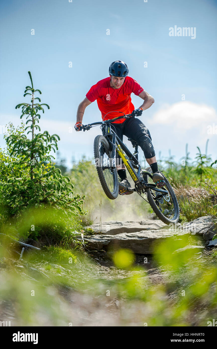 Un vélo de montagne monte un sentier rocheux au Bikepark de galles près de la ville de Merthyr Tydfil au Pays de Galles. Banque D'Images