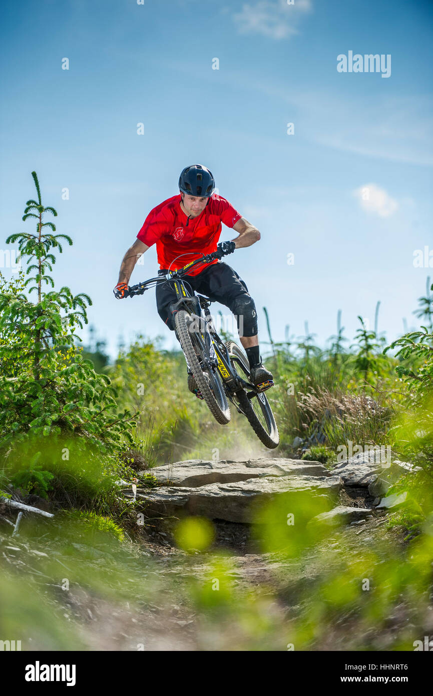 Un vélo de montagne monte un sentier rocheux au Bikepark de galles près de la ville de Merthyr Tydfil au Pays de Galles. Banque D'Images