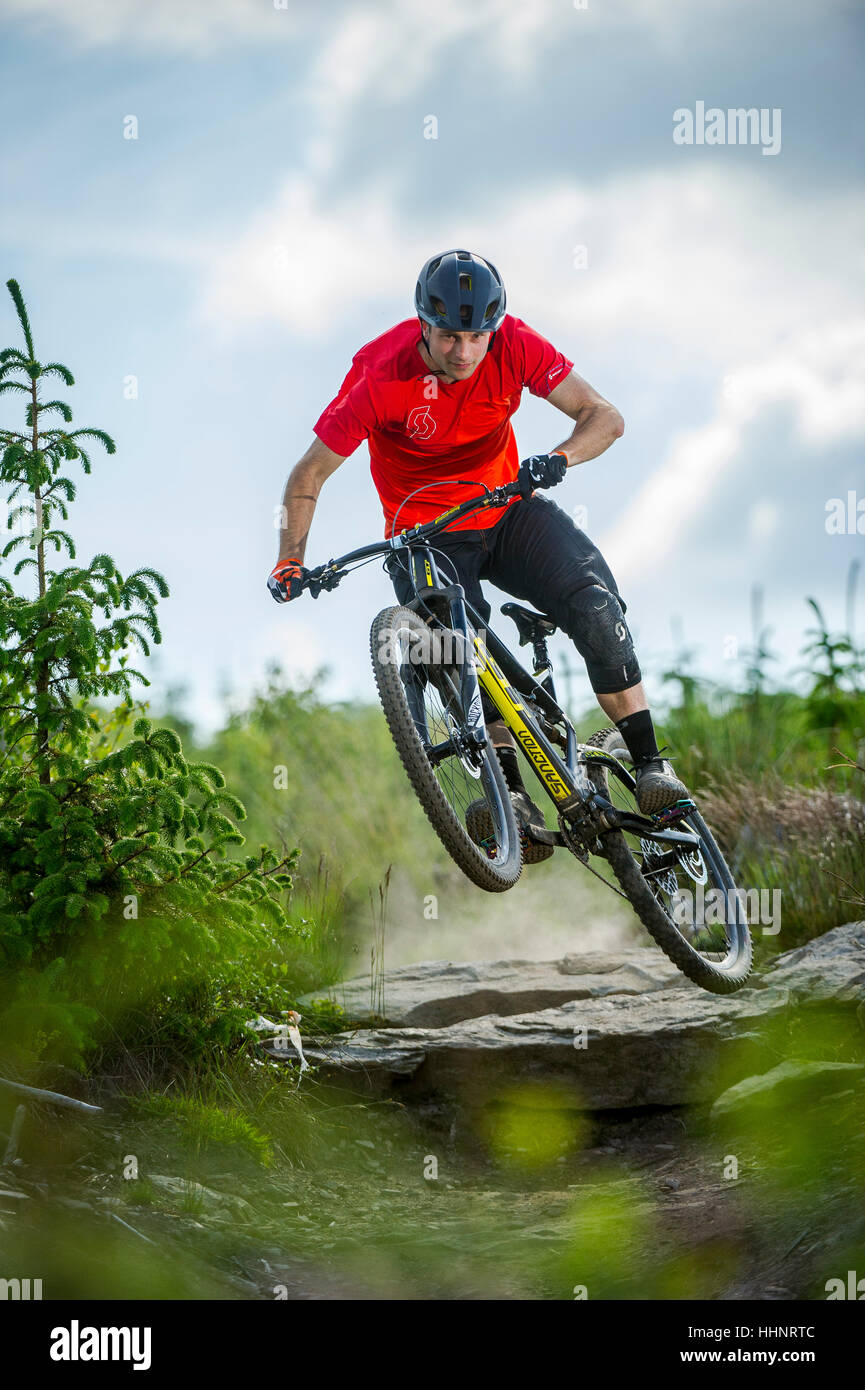 Un vélo de montagne monte un sentier rocheux au Bikepark de galles près de la ville de Merthyr Tydfil au Pays de Galles. Banque D'Images