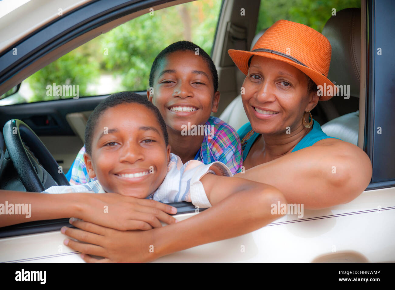 Portrait de mère et fils jumeaux leaning on car window Banque D'Images