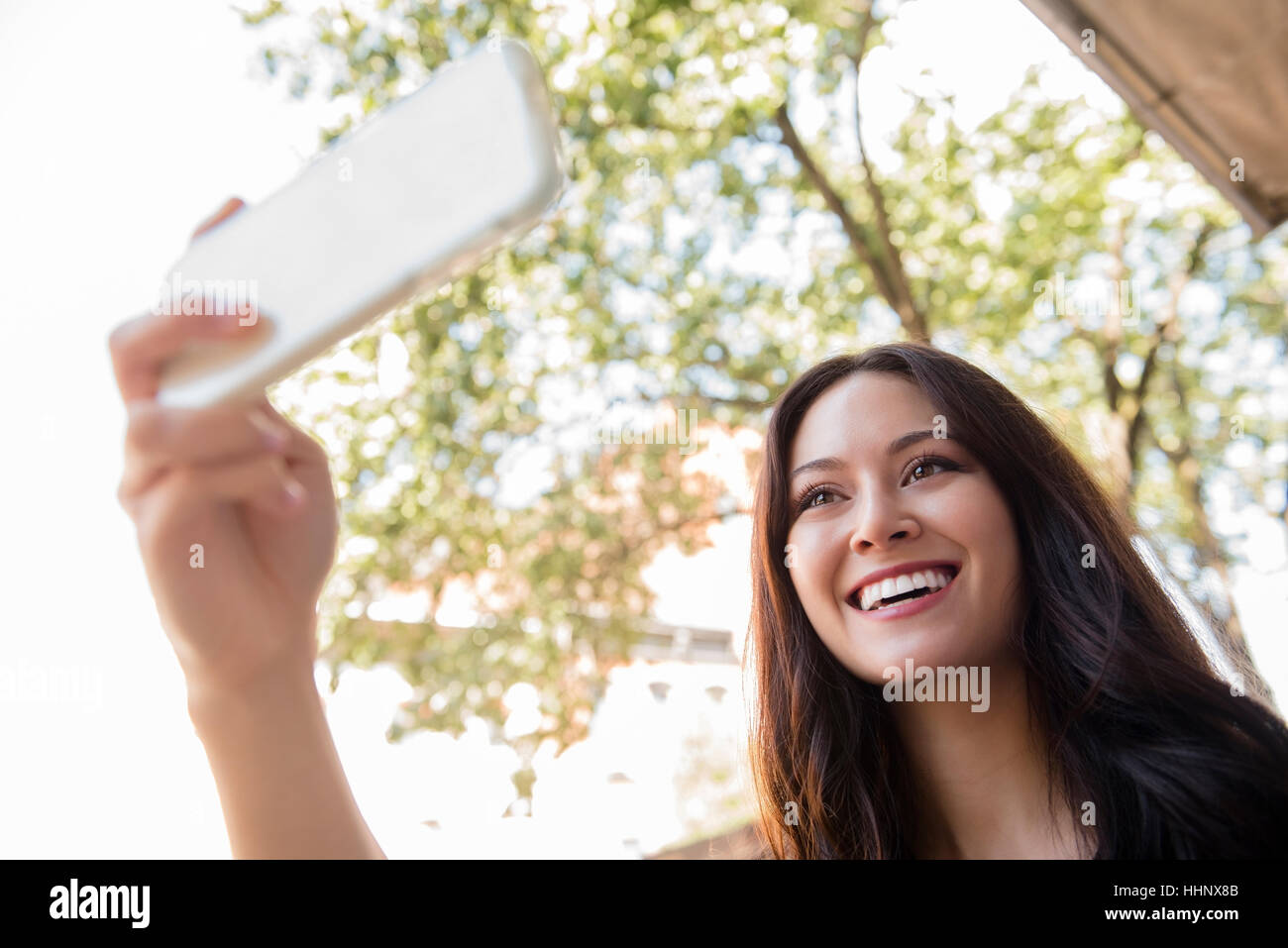 Smiling woman posing for Thai selfies téléphone cellulaire Banque D'Images