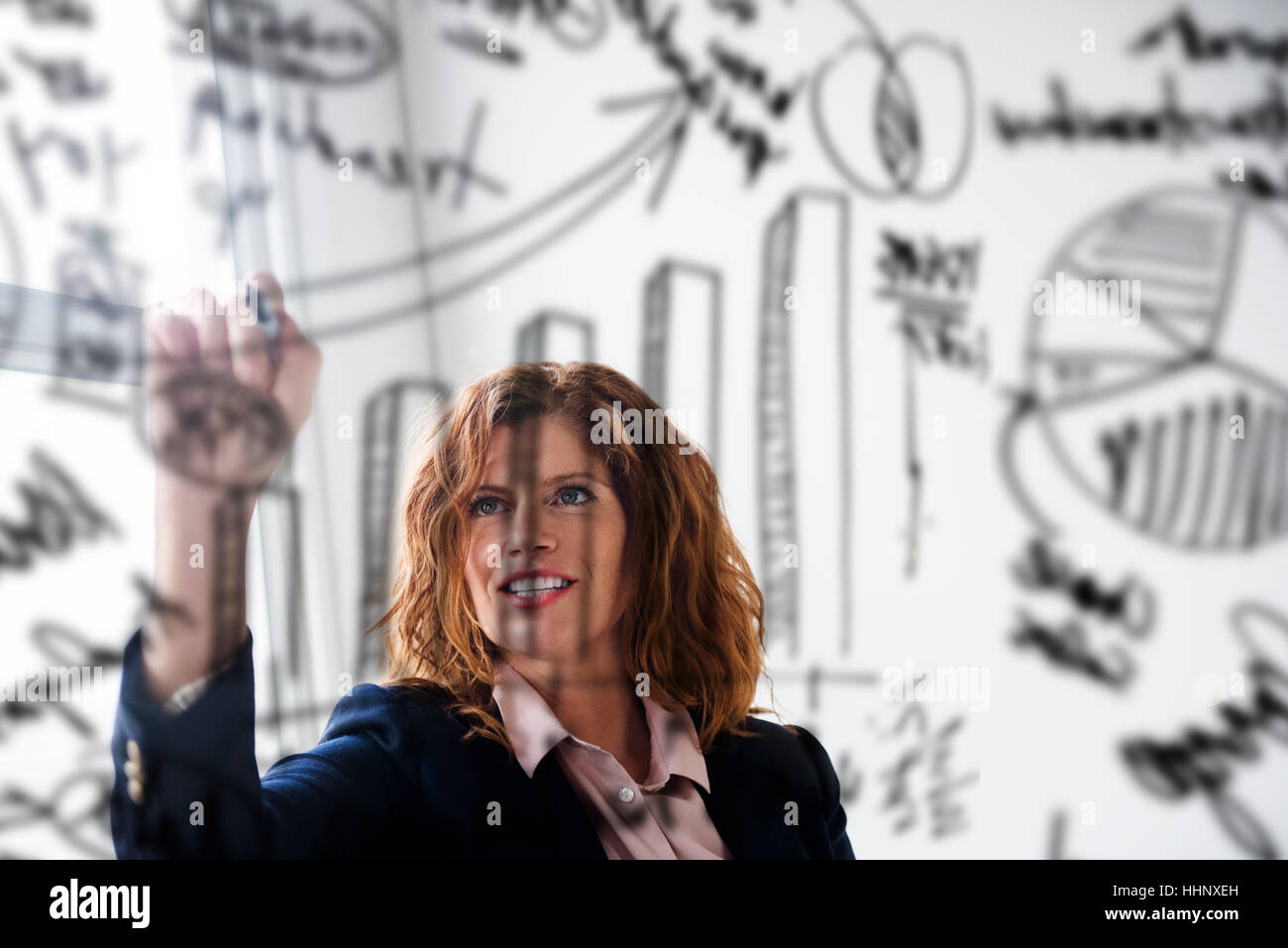 Caucasian businesswoman dimensions des tableaux sur un mur de verre Banque D'Images