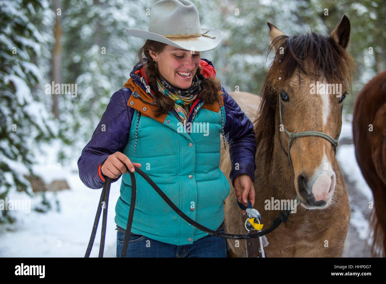 Smiling Caucasian woman holding cours de cheval en hiver Banque D'Images