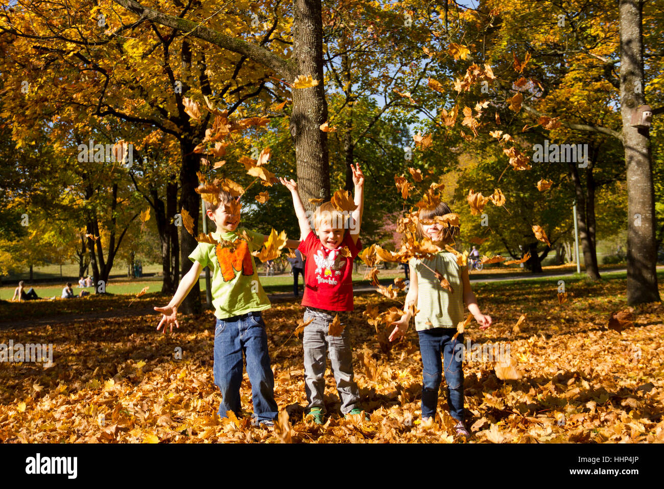 Enfants jouant dans les feuilles Banque D'Images