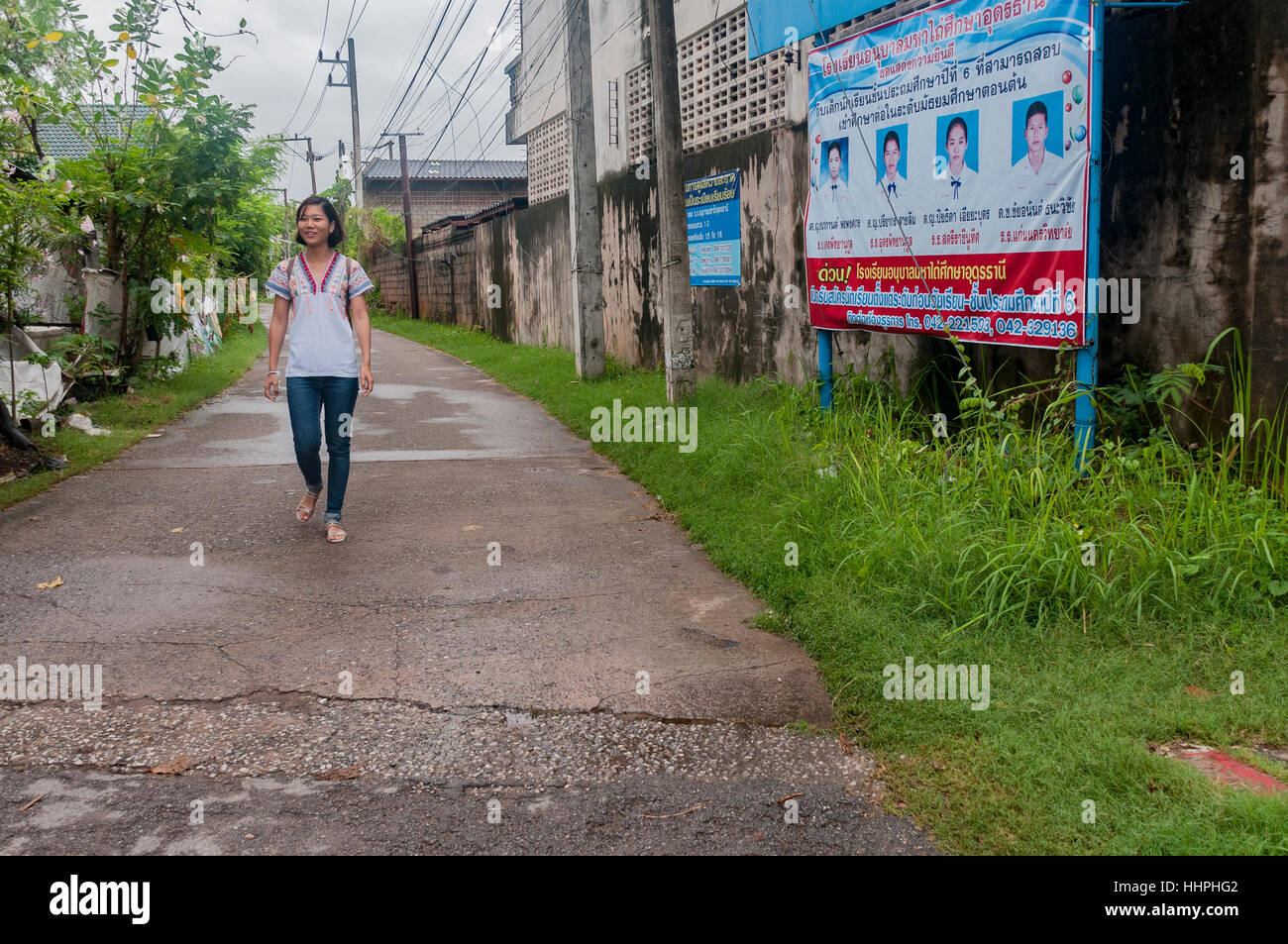 Une jolie jeune femme asiatique en blue-jeans et des sandales est marchant dans une ruelle d'Udon Thani, au nord-est de la Thaïlande. Banque D'Images
