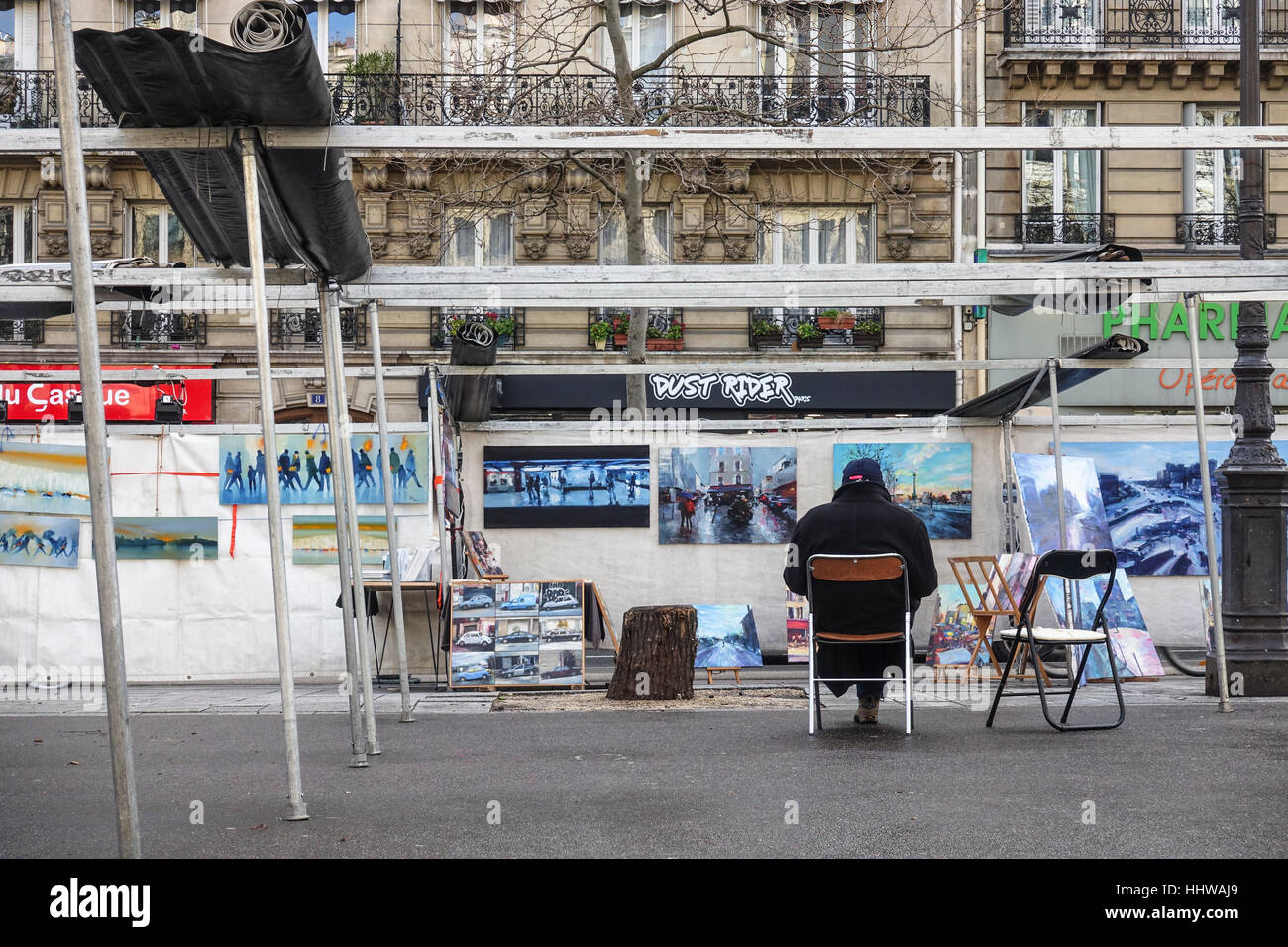 Vendeur d'Art Vente de tableaux assis devant son échoppe, Paris. Bastille, France. Banque D'Images