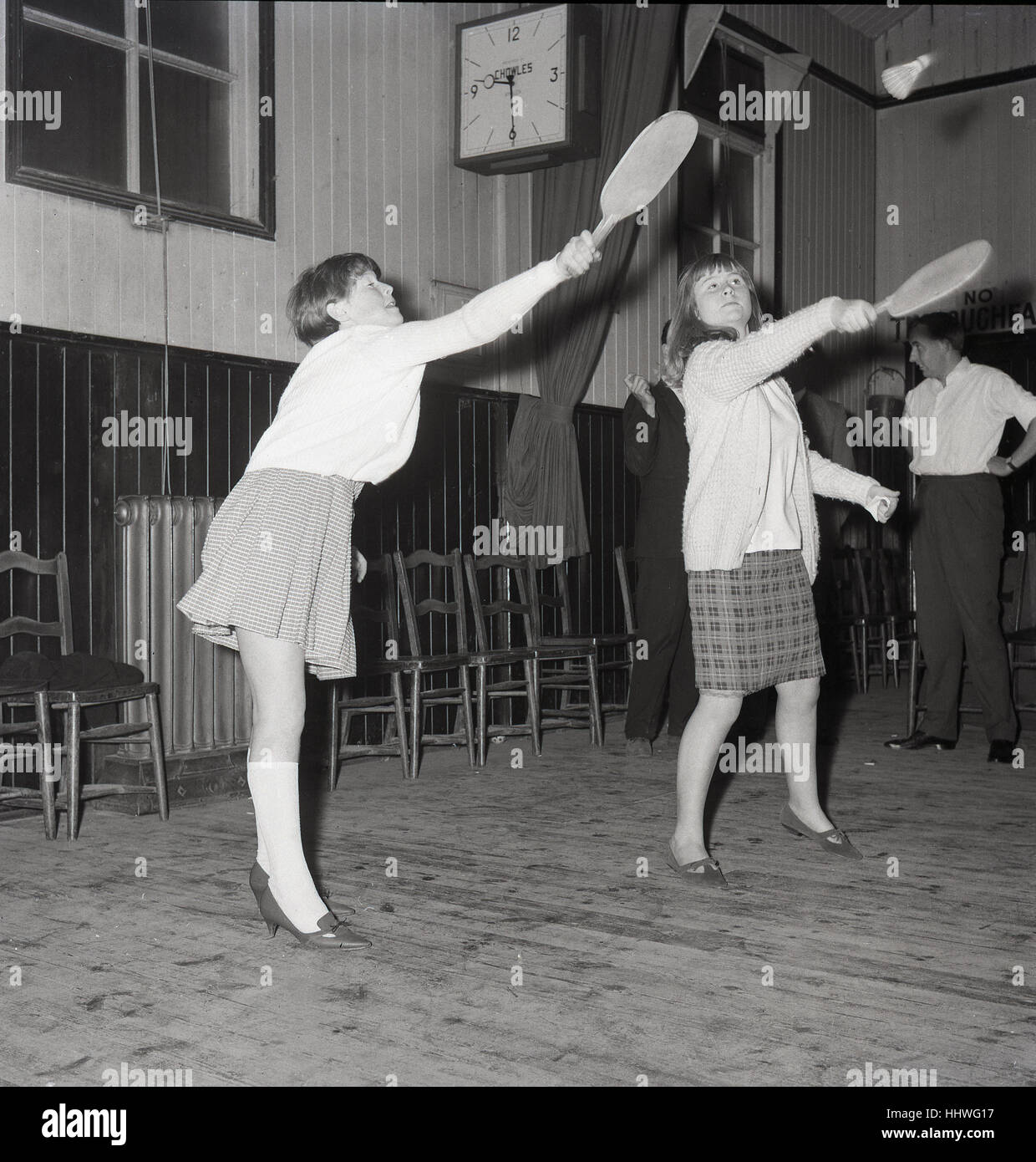 Années 1960, historiques, les jeunes filles adultes jouer au badminton ou volants à un club de jeunes à l'intérieur d'une salle locale. Banque D'Images