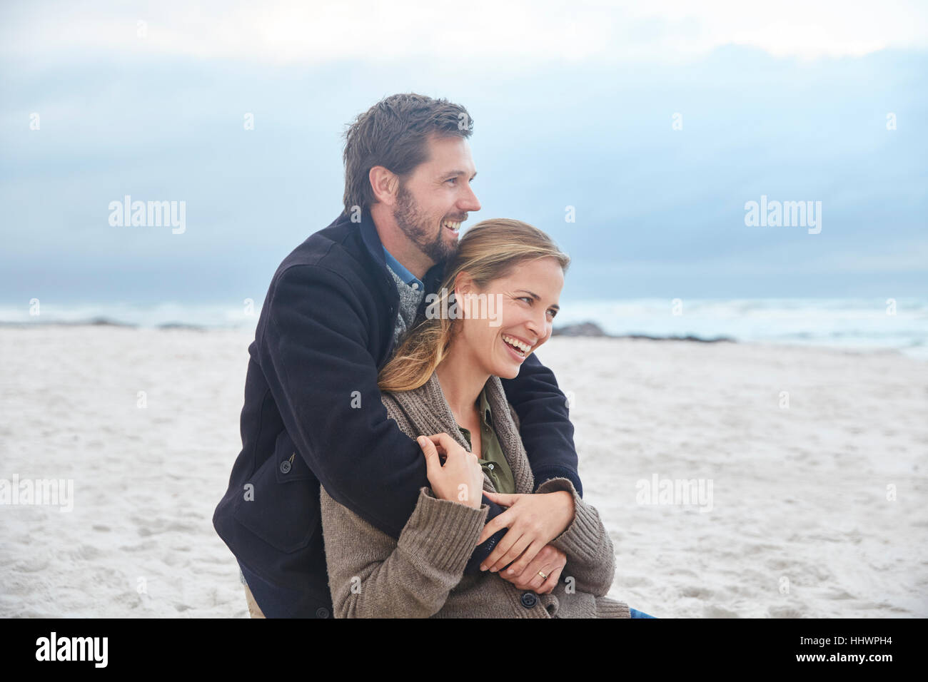 Heureux couple hugging on winter beach Banque D'Images