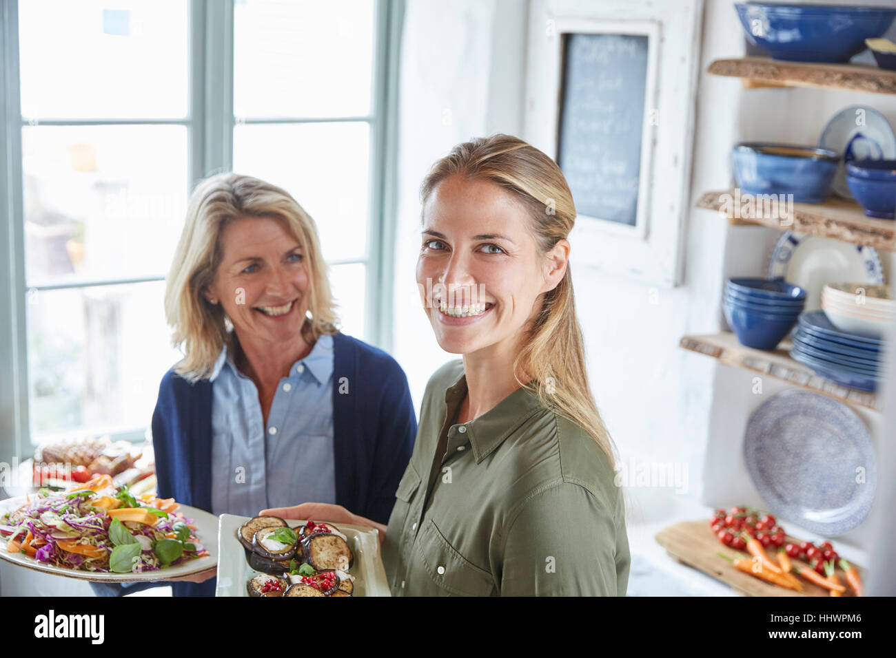 Portrait of smiling mother and daughter servant de la nourriture Banque D'Images