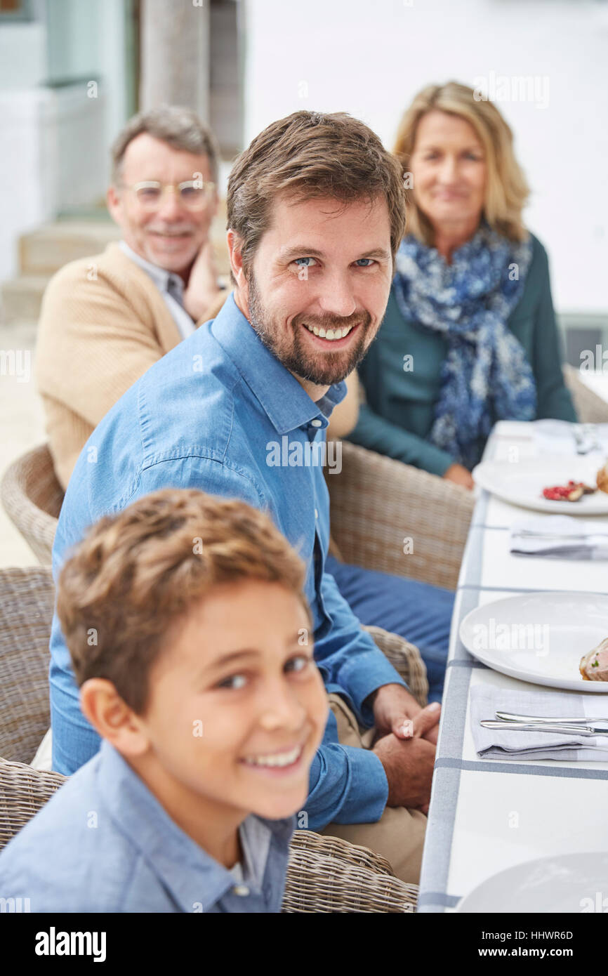 Portrait of smiling multi-generation family enjoying patio le déjeuner Banque D'Images