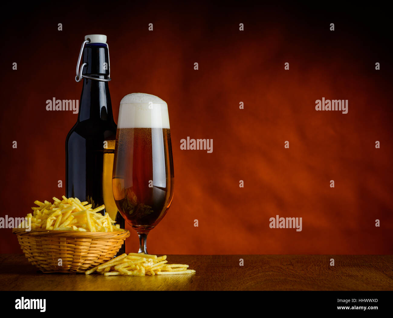 Aliments malsains. Potato-Sticks salé et une bouteille et un verre de bière sur la table en bois avec haut-copy-space Banque D'Images