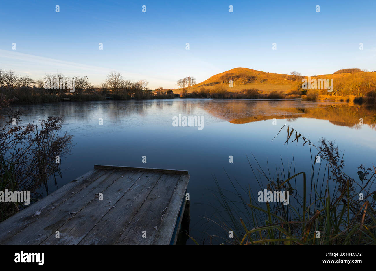 Summerhouse Hill sur le Kent Downs reflétée dans les étangs Beachborough à l'aube. Banque D'Images