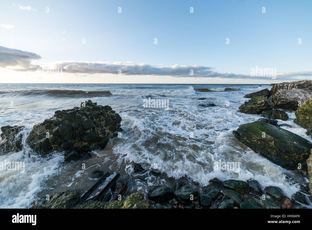 Le concassage des pierres et des vagues ruines du vieux fort au coucher du soleil sur la plage Banque D'Images