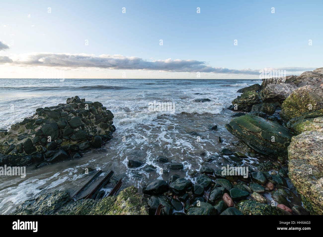 Le concassage des pierres et des vagues ruines du vieux fort au coucher du soleil sur la plage Banque D'Images