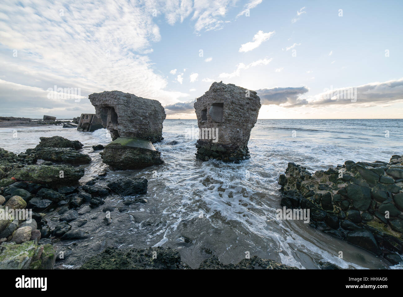 Le concassage des pierres et des vagues ruines du vieux fort au coucher du soleil sur la plage Banque D'Images