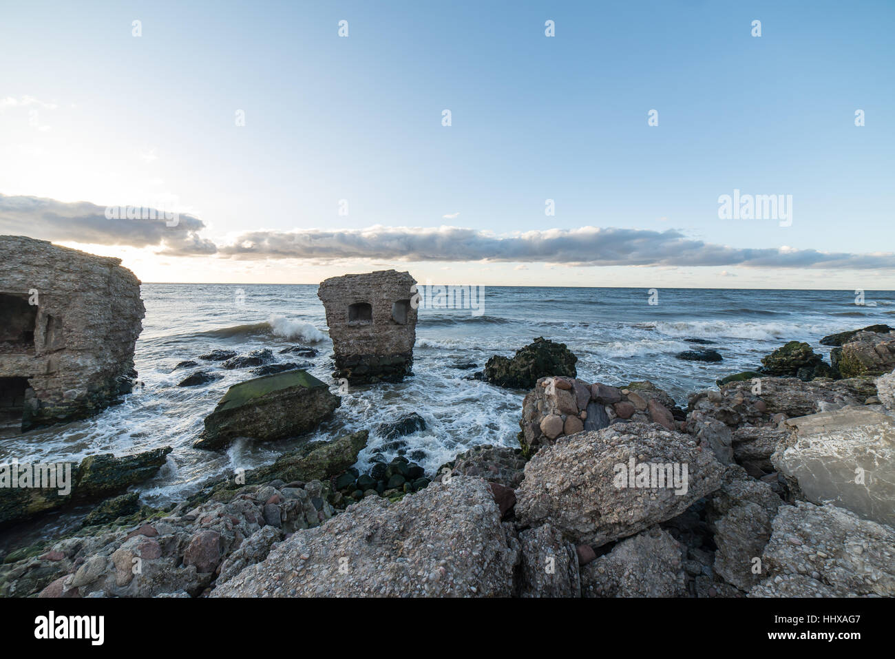 Le concassage des pierres et des vagues ruines du vieux fort au coucher du soleil sur la plage Banque D'Images