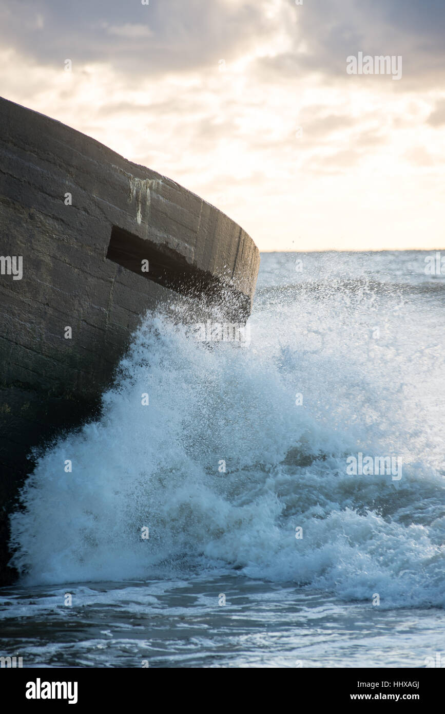 Le concassage des pierres et des vagues ruines du vieux fort au coucher du soleil sur la plage Banque D'Images