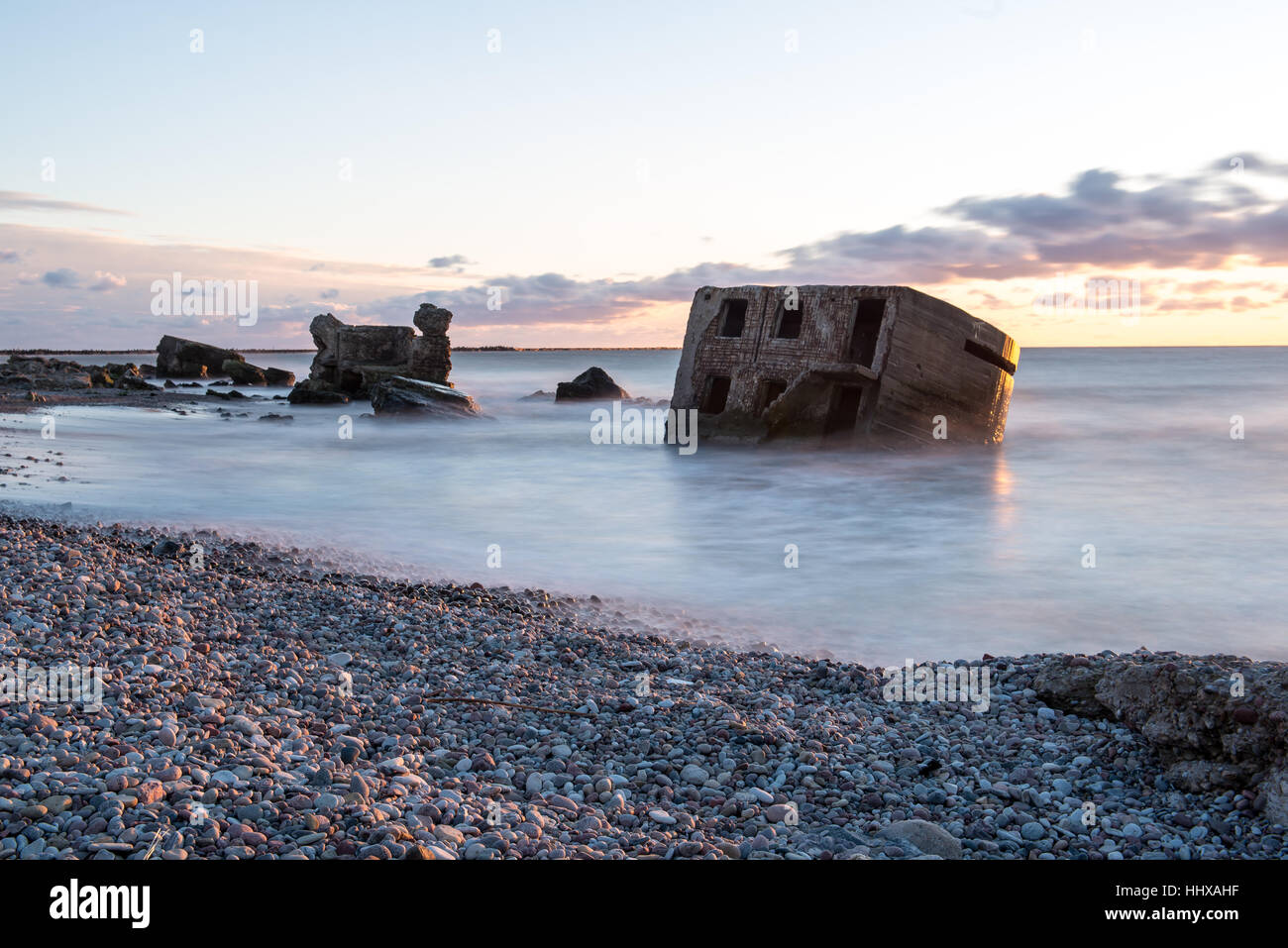 Le concassage des pierres et des vagues ruines du vieux fort au coucher du soleil sur la plage Banque D'Images