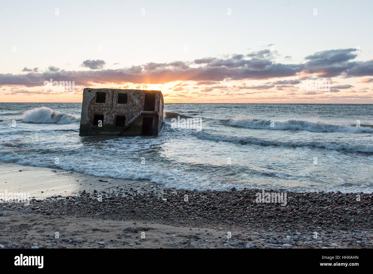 Le concassage des pierres et des vagues ruines du vieux fort au coucher du soleil sur la plage Banque D'Images