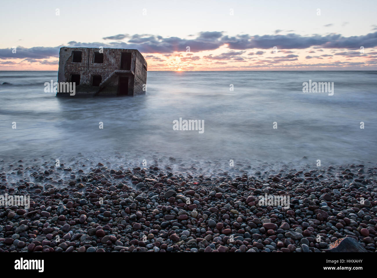 Le concassage des pierres et des vagues ruines du vieux fort au coucher du soleil sur la plage Banque D'Images