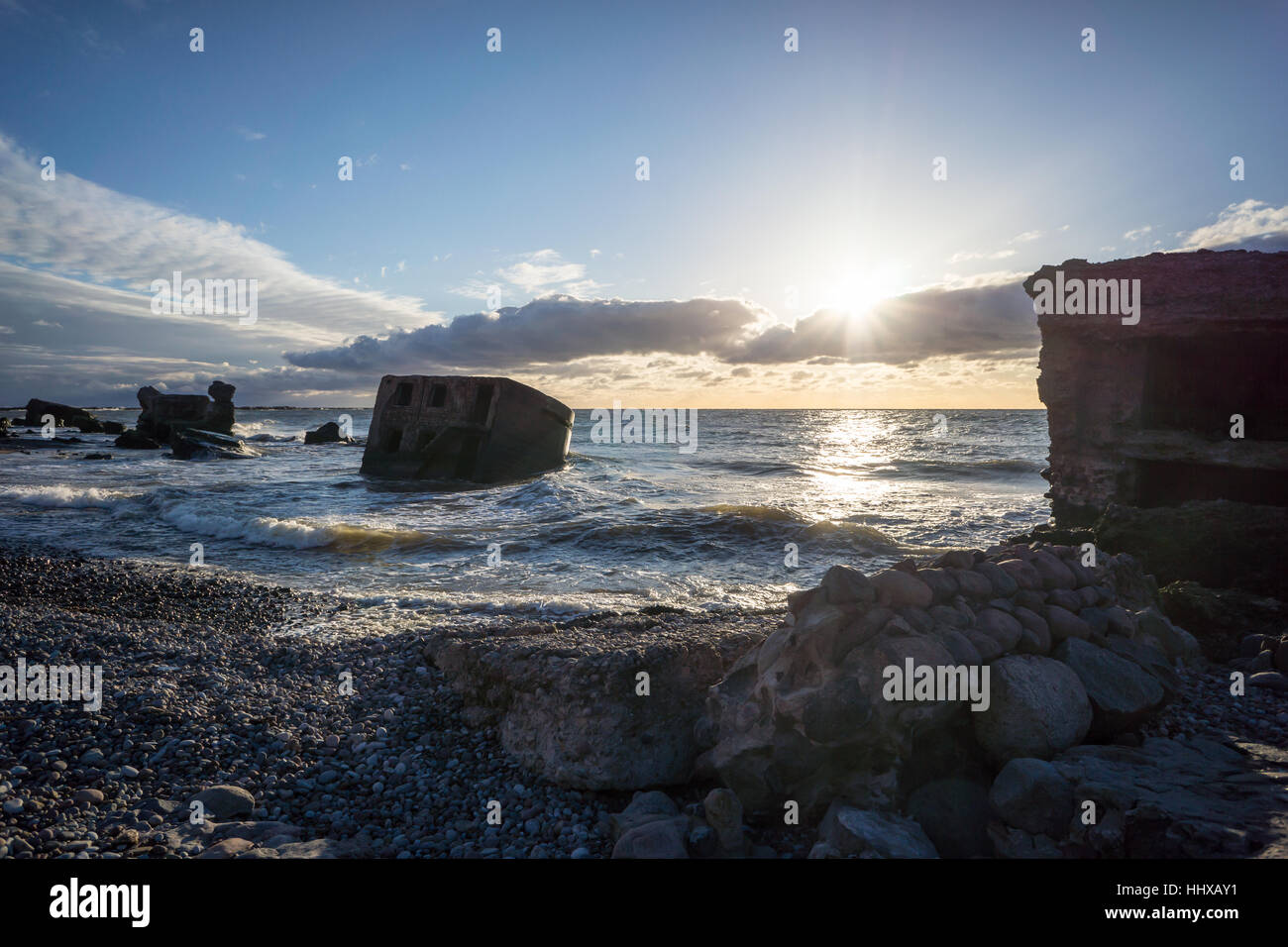 Le concassage des pierres et des vagues ruines du vieux fort au coucher du soleil sur la plage Banque D'Images
