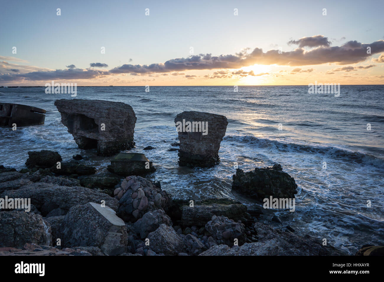 Le concassage des pierres et des vagues ruines du vieux fort au coucher du soleil sur la plage Banque D'Images