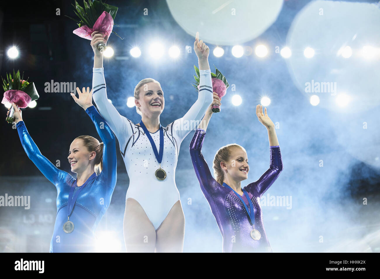 Les gymnastes féminines célébrant la victoire en agitant le podium des gagnants Banque D'Images