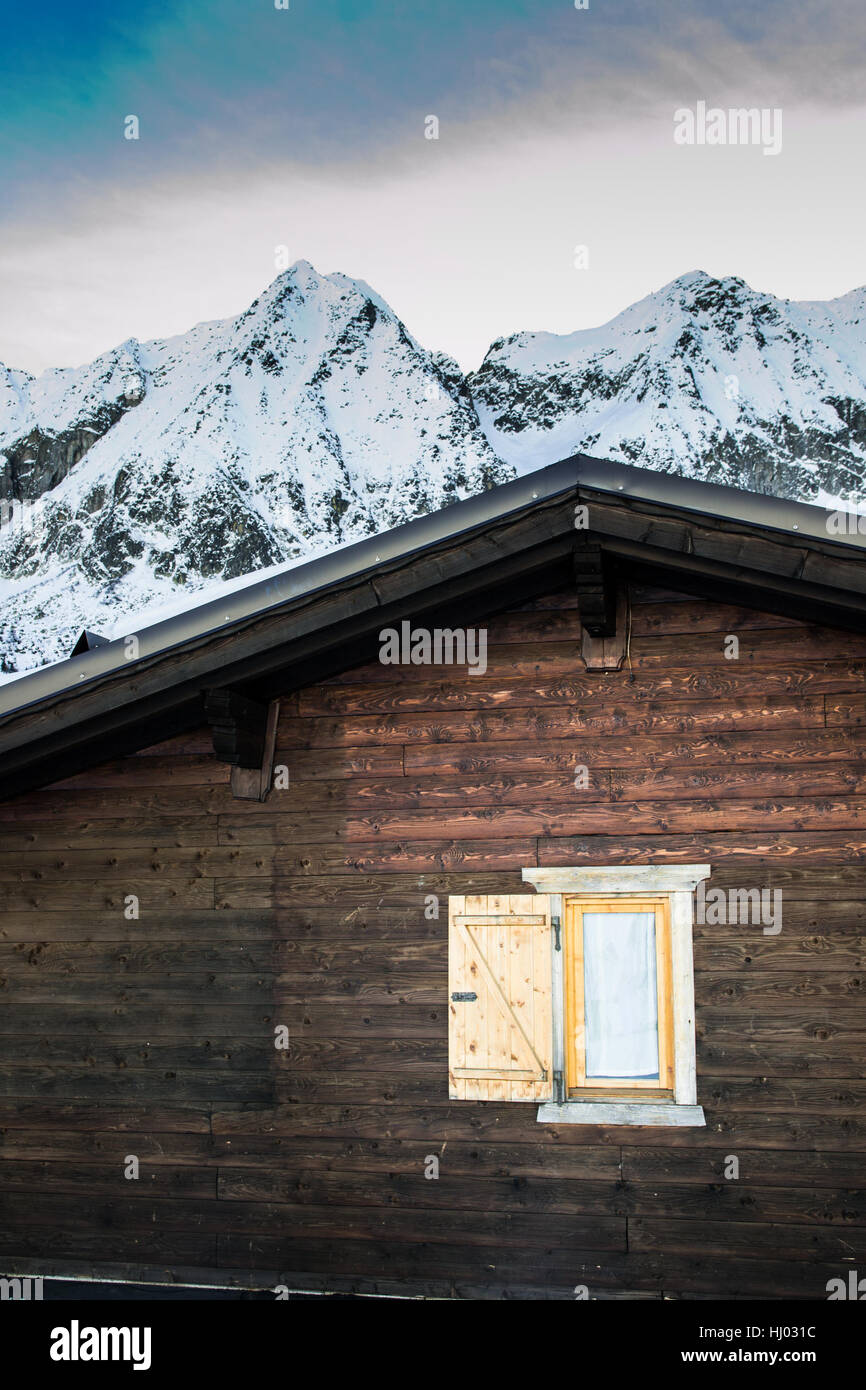 Détail de chalet de montagne avec des montagnes couvertes de neige sur l'arrière-plan. Banque D'Images