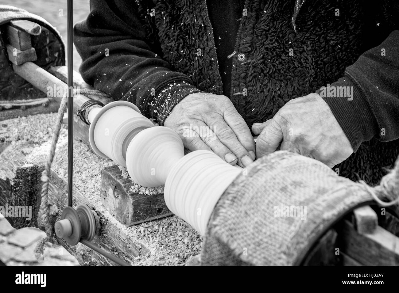 Un artisan sculpte un morceau de bois à l'aide d'une vieille tour manuel. Banque D'Images