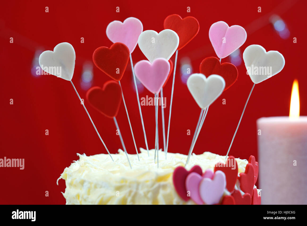 Belle St Valentines Day party table avec showstopper rouge, blanc et coeurs roses gâteau double couche, avec glaçage au chocolat blanc. Banque D'Images