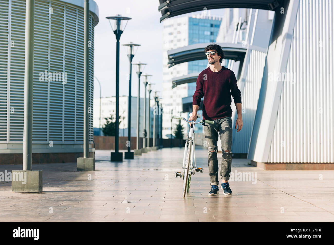 Utdoor portrait du beau jeune homme avec pignon fixe vélo dans la rue. Banque D'Images