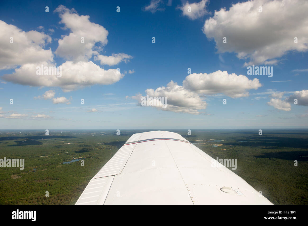 Une vue aérienne d'un petit avion d'un ciel bleu avec des nuages blancs gonflées. Banque D'Images