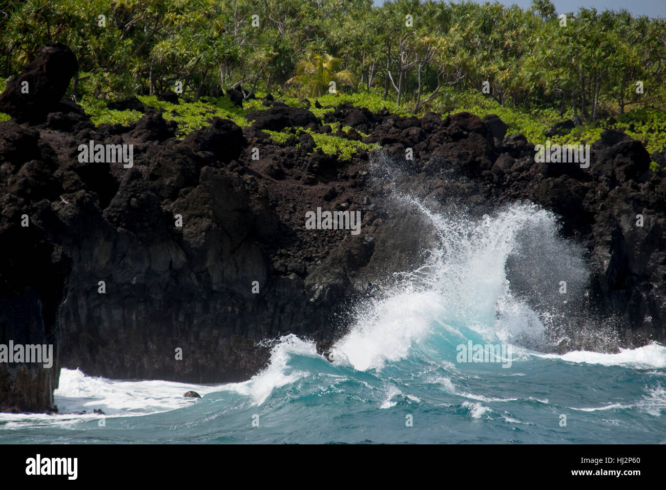Un littoral volcanique rocheux avec des vagues de l'océan turquoise. Banque D'Images