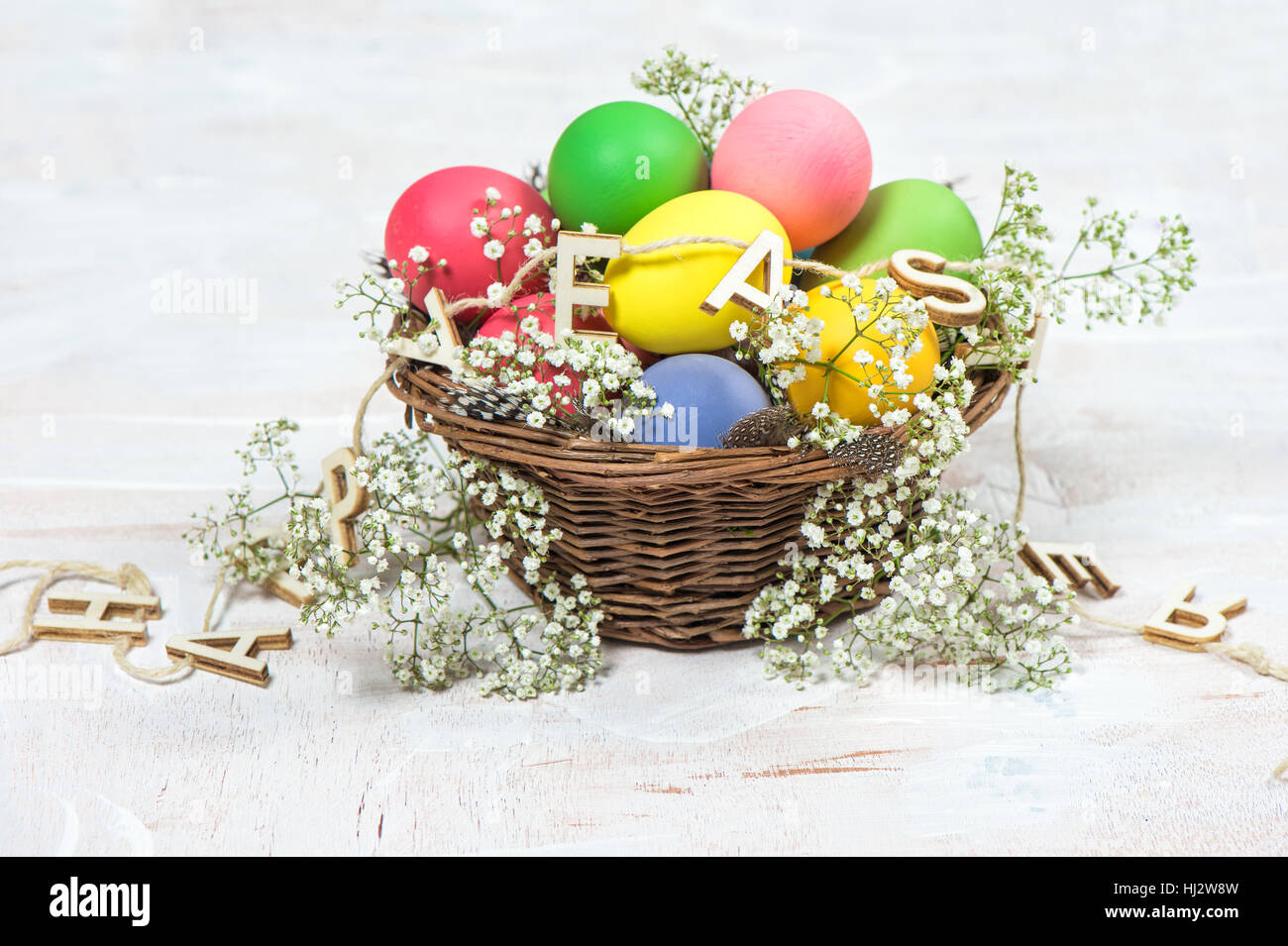 Oeufs de Pâques avec des fleurs sur fond lumineux en bois. Décoration de fête Banque D'Images