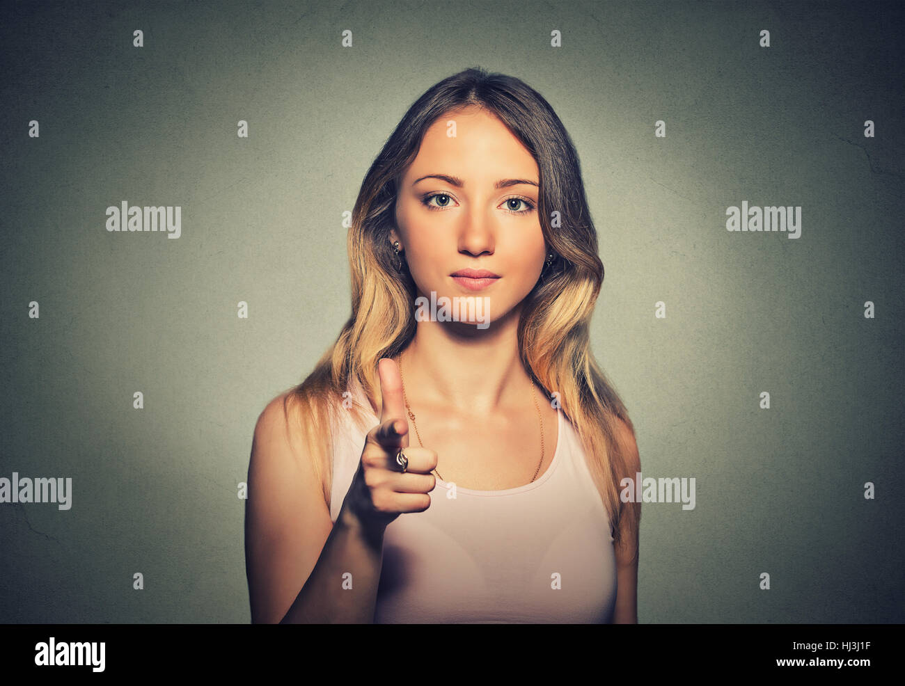 Jolie femme pointant son doigt au geste de l'appareil ...
