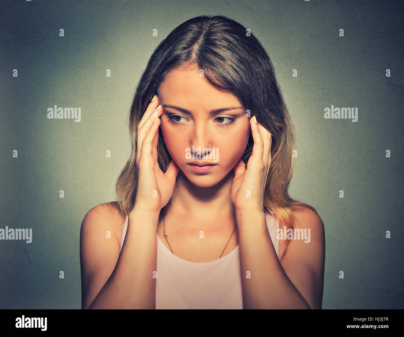 Portrait d'une femme triste sur fond gris. L'expression faciale des émotions négatives réaction sentiment Banque D'Images