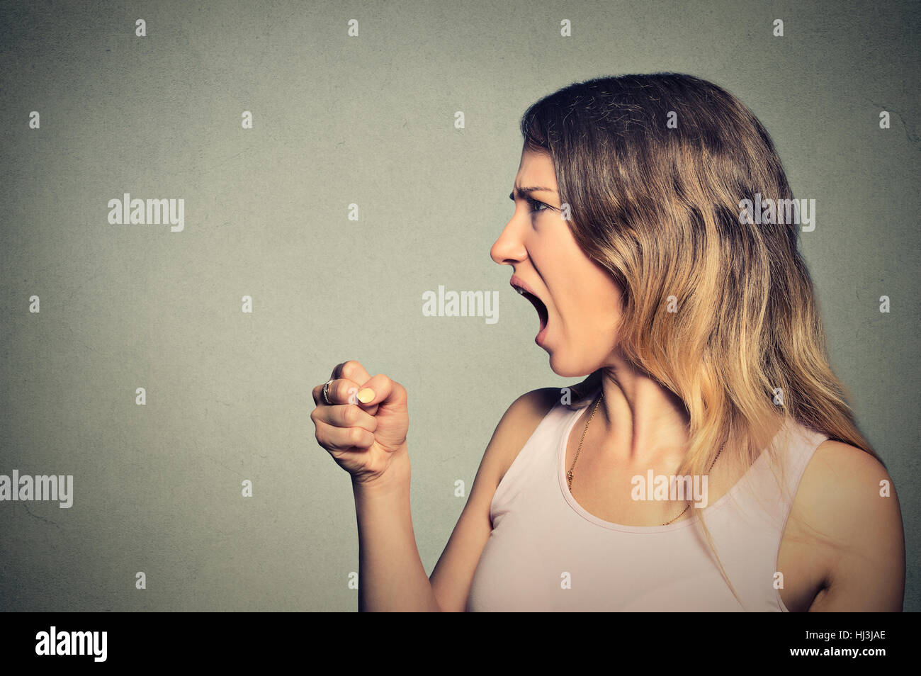 Femme en colère hurlent de poing jusqu'à l'air Banque D'Images