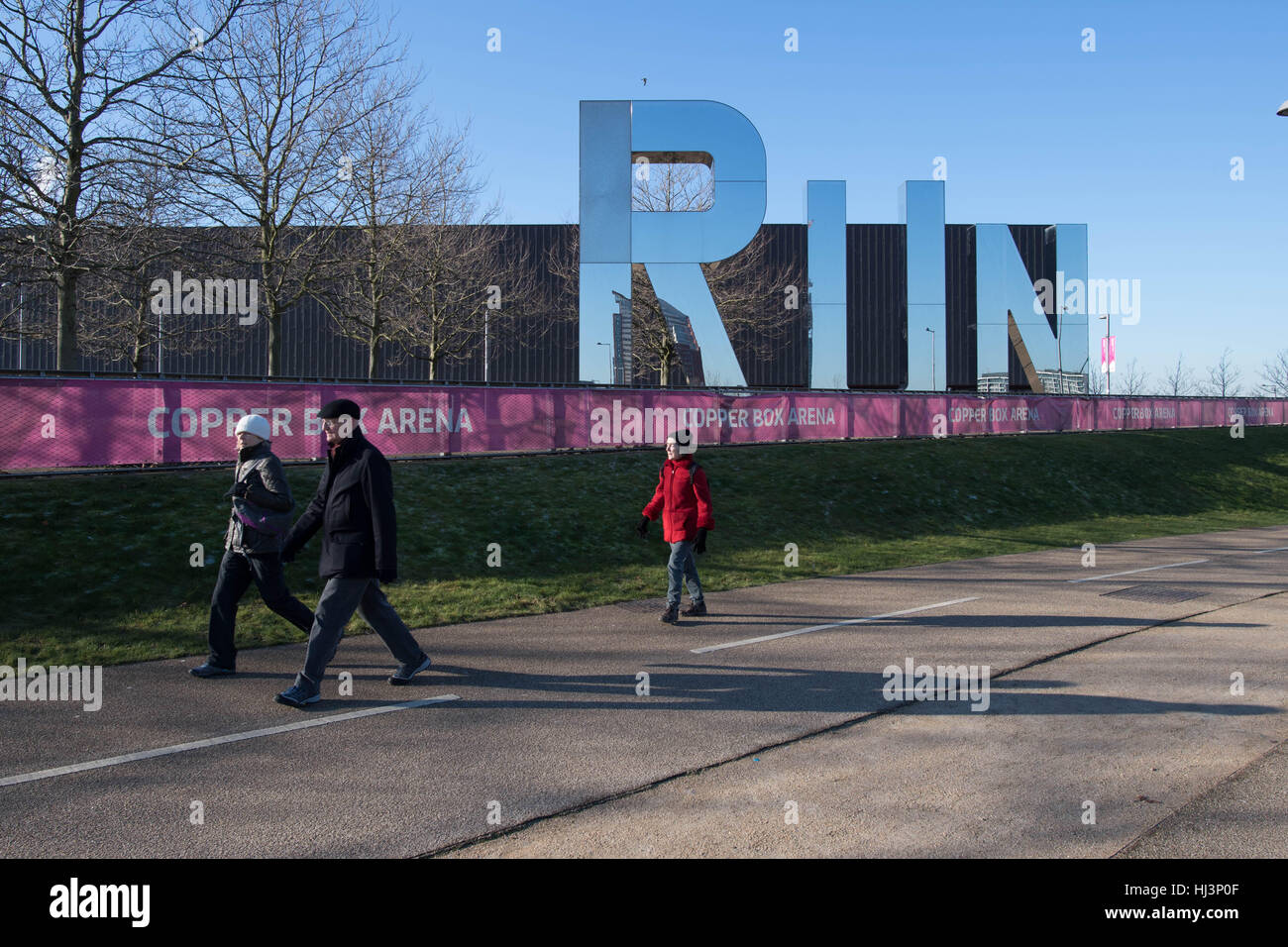 Les marcheurs passer la boîte de cuivre Arena au Queen Elizabeth Olympic Park à Stratford, l'Est de Londres. La London Legacy Development Corporation a établi un plan ambitieux visant à régénérer la zone autour du site des Jeux Olympiques de 2012, la création d'un mélange d'habitations, locaux professionnels et équipements publics. Banque D'Images