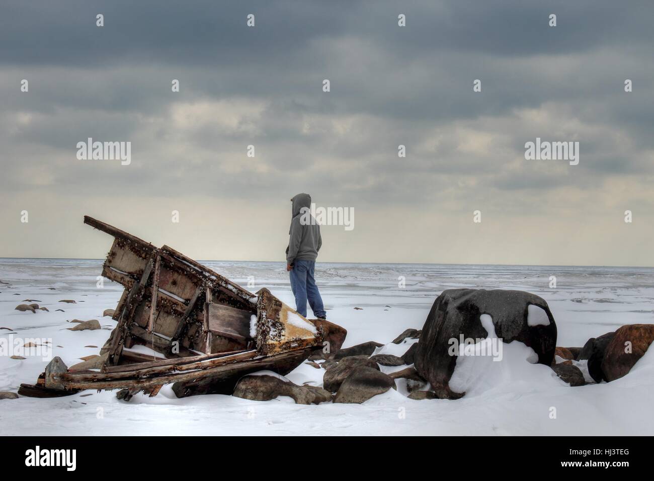 Shipwreck Island. Adolescent dans un hoodie comité permanent par un naufrage à la désolation sur un paysage d'hiver. Banque D'Images