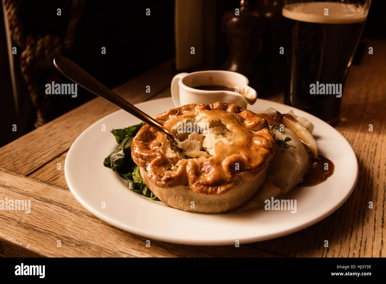 Tourte au poulet salé traditionnel servi dans un pub avec de la bière à l'arrière-plan Banque D'Images